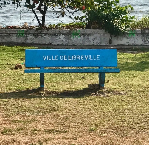 Photographie d'un banc bleu de Libreville en bord de mer.